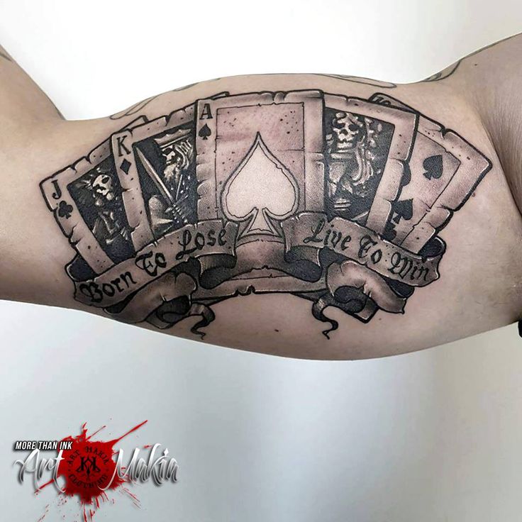 a man's arm with playing cards tattoo on it