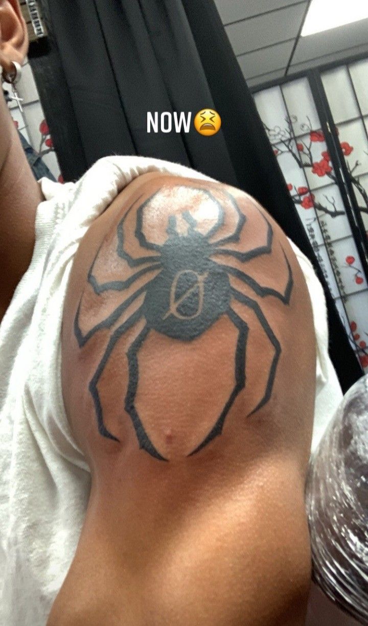 a man with a spider tattoo on his arm