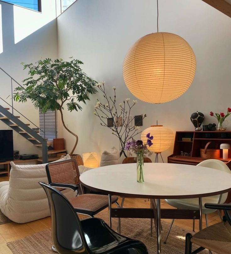 a living room filled with lots of furniture and a round white table surrounded by chairs