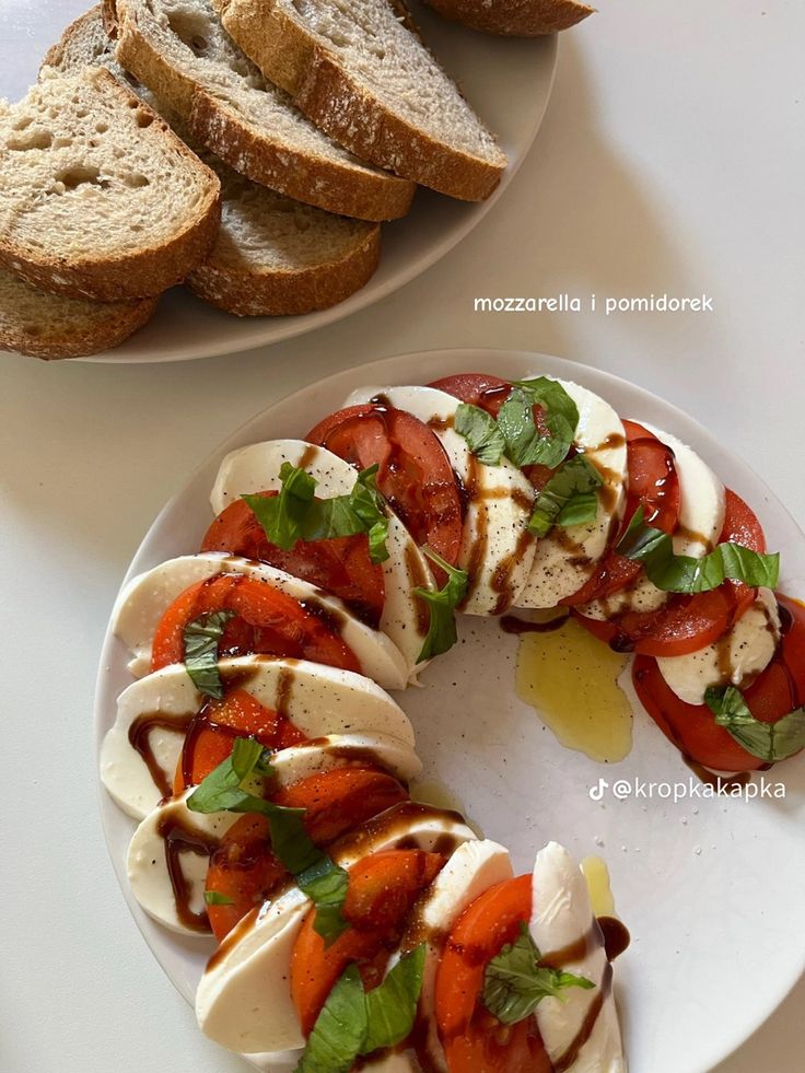 sliced bread, tomatoes and mozzarella on a white plate next to slices of bread