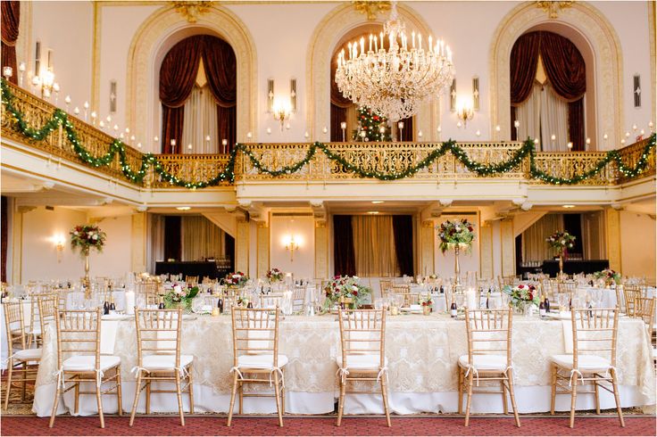 an elegant ballroom with chandeliers, tables and chairs