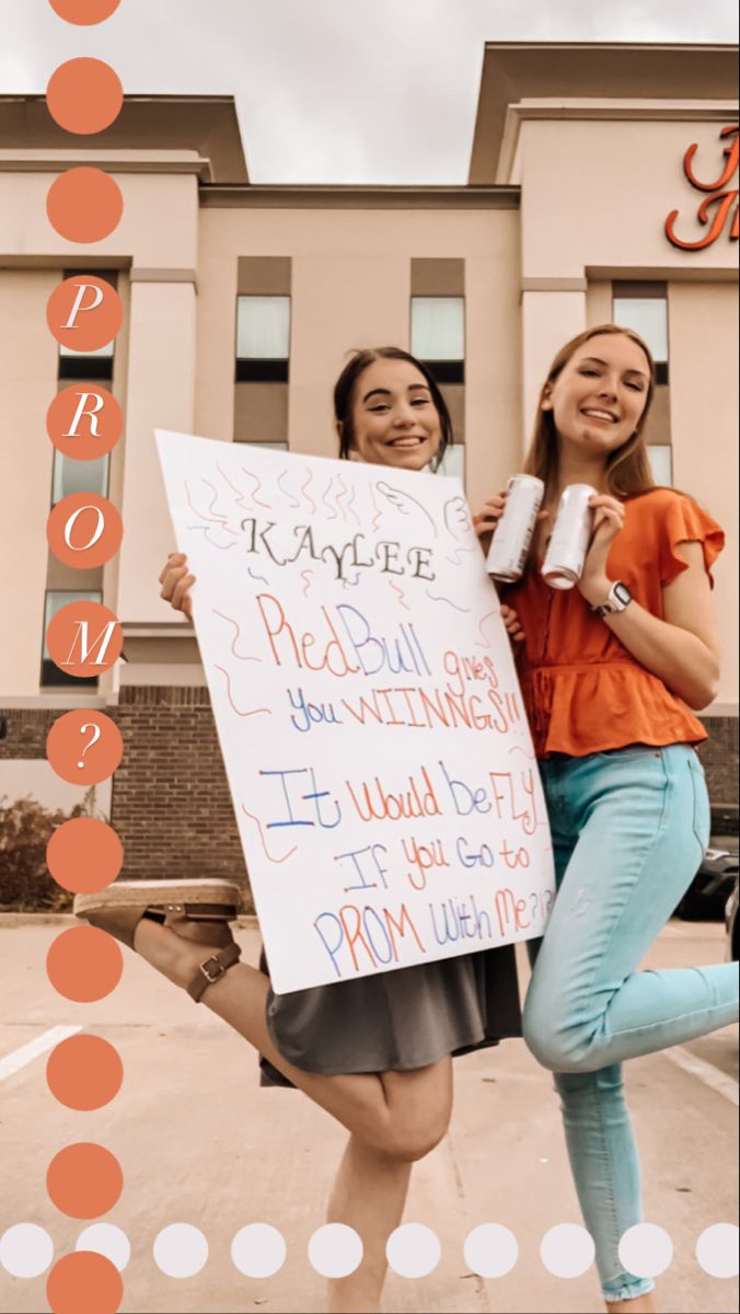 two girls holding up signs in front of a building