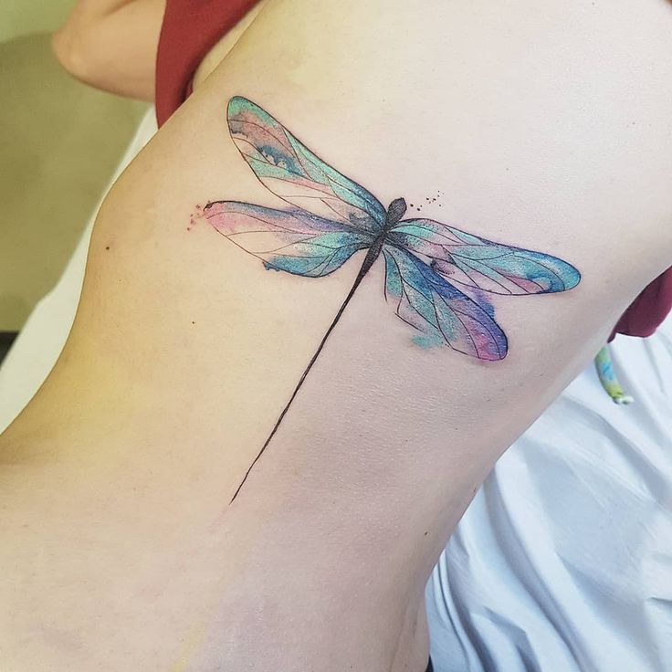 a woman's thigh with a tattoo of a dragonfly on her lower back