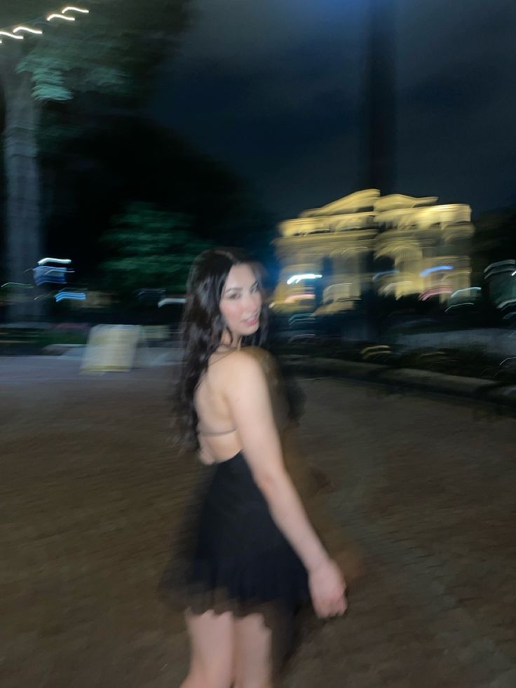 a woman in a black dress is walking