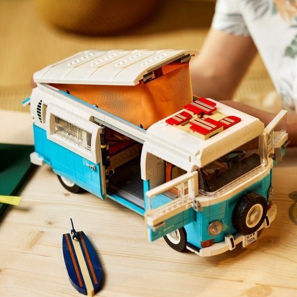 a blue and white toy bus on top of a wooden table next to other toys