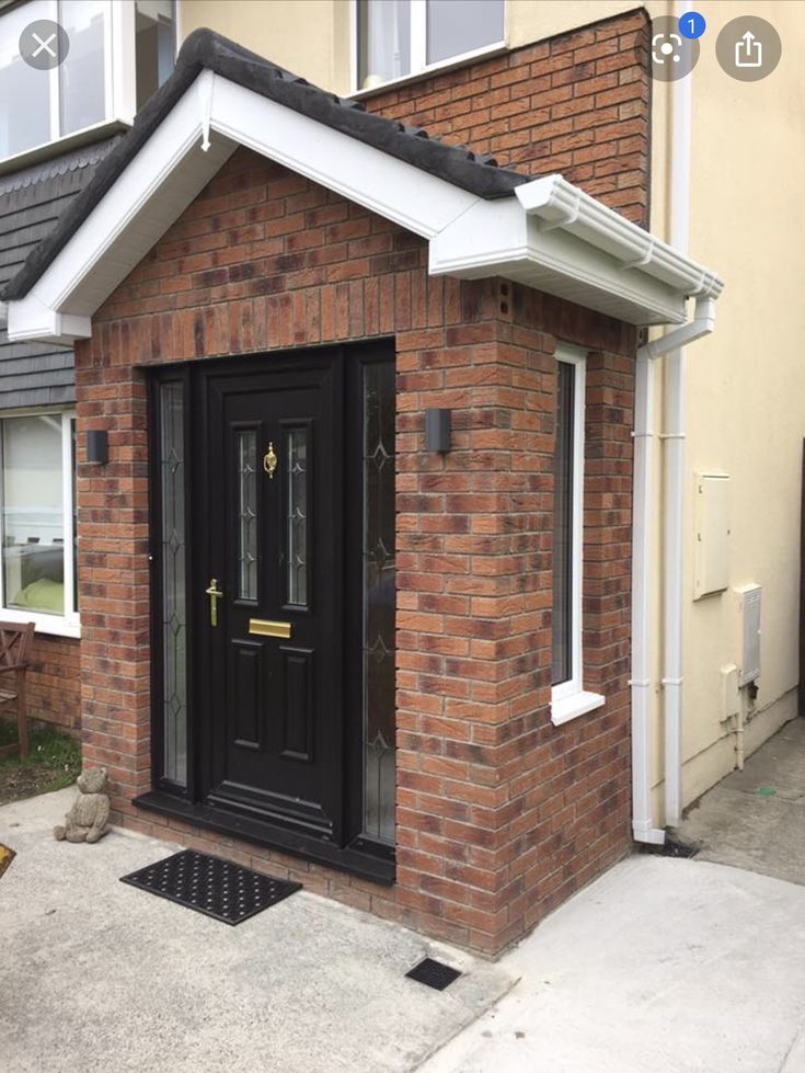 a small brick house with a black front door