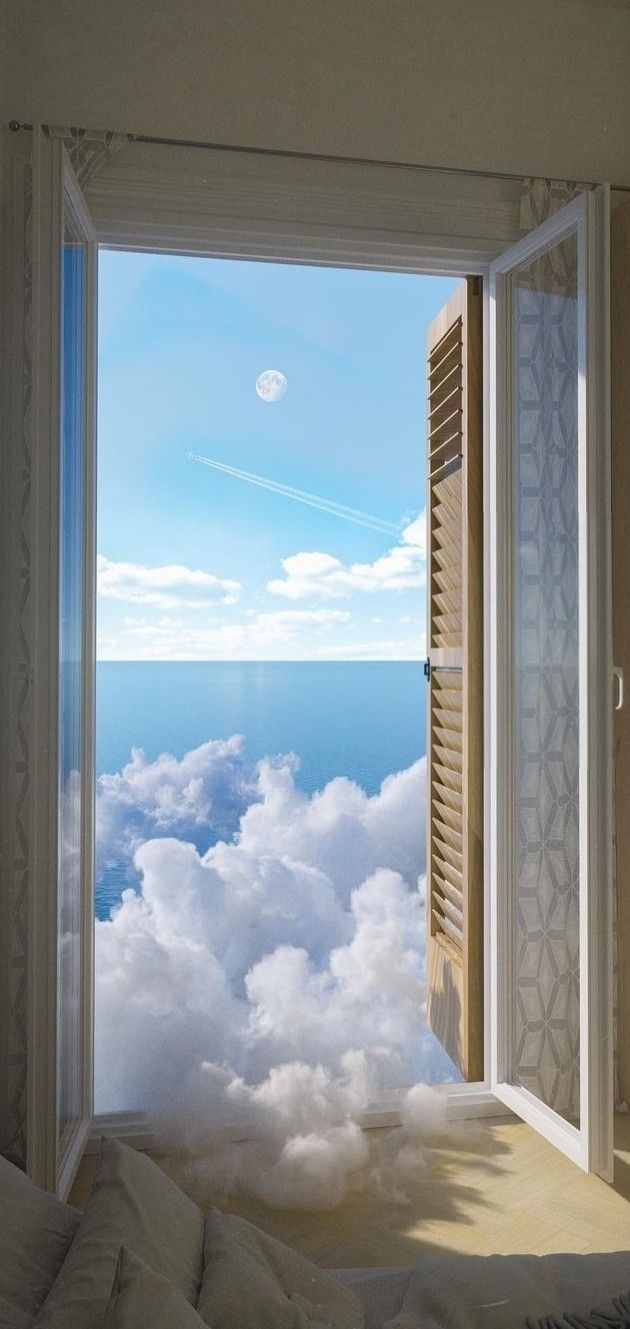 an open window looking out onto the clouds and ocean from a bed in a room