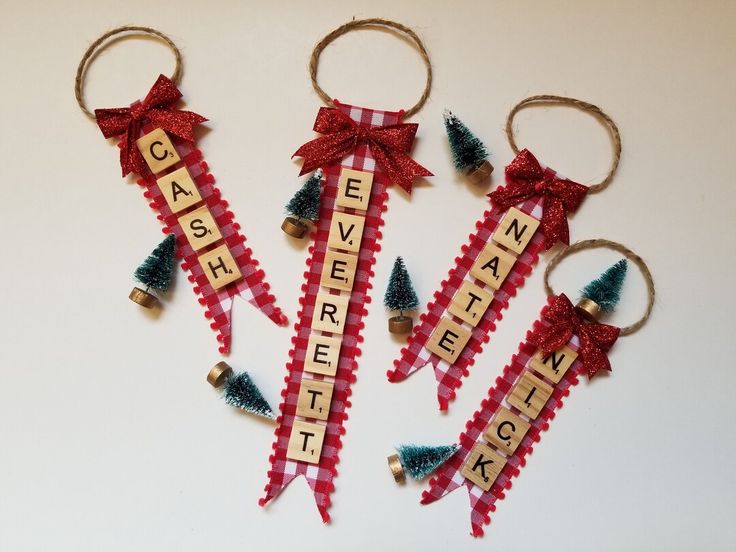 four wine corks with words on them and christmas trees hanging from the top one