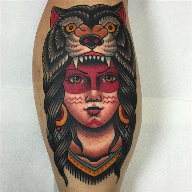 a woman with a wolf's head tattoo on her leg