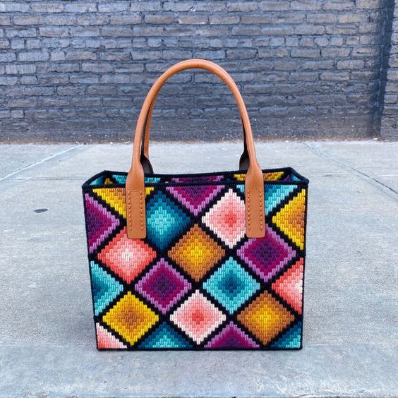 a colorful handbag sitting on top of a sidewalk