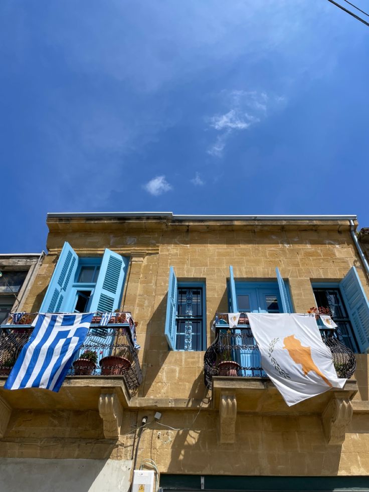 an apartment building with blue shutters and balconies