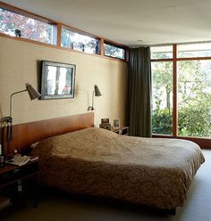 a bedroom with a large bed and two windows