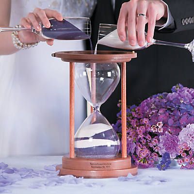 the bride and groom are pouring sand into their hourglasses