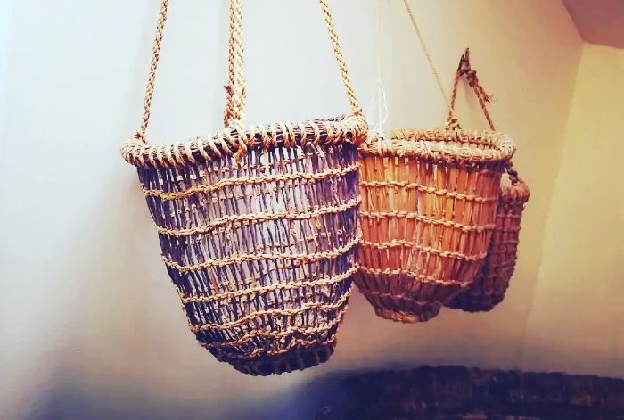 two baskets hanging from chains on the wall