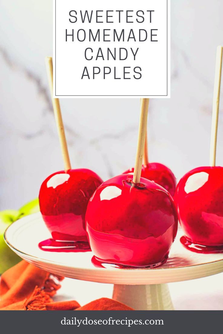 three apples on a plate with toothpicks sticking out of the top one is red