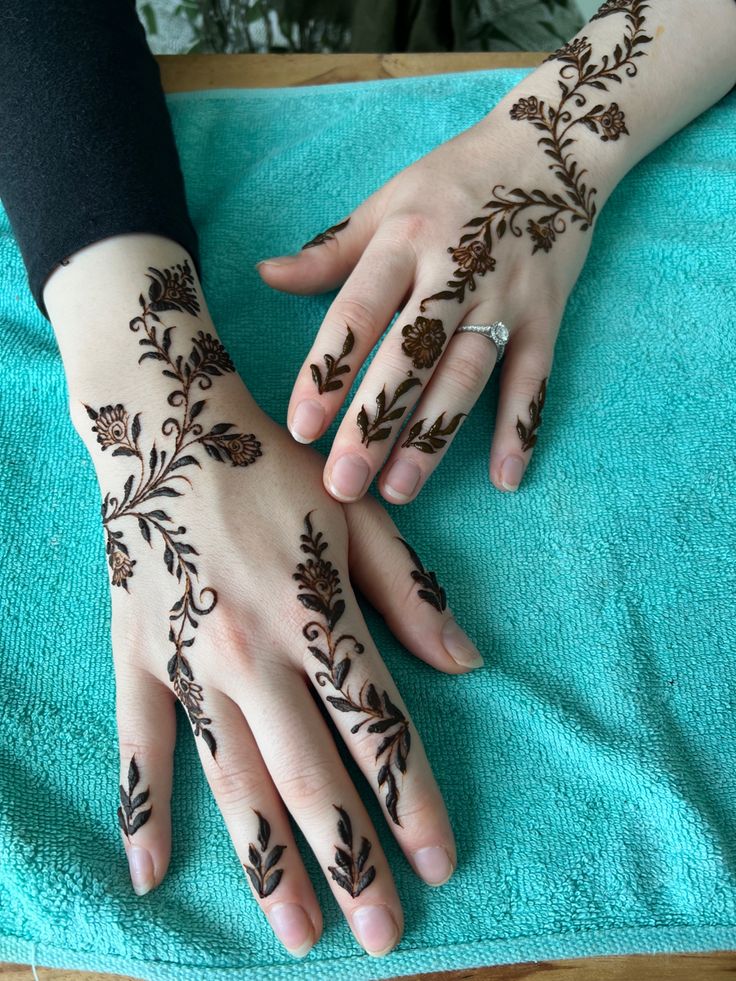 two hands with henna tattoos on them