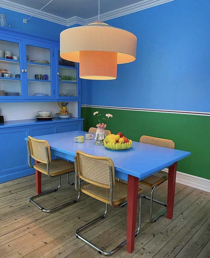 a dining room with blue walls and wooden floors