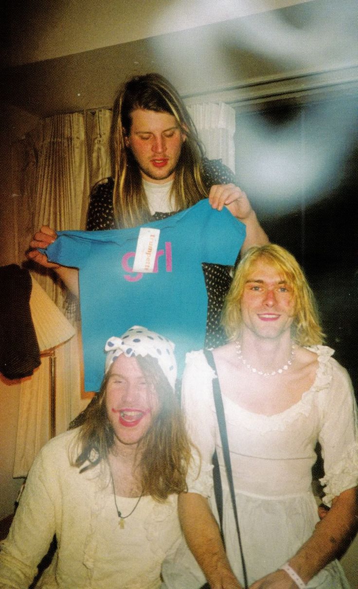 two women and a man holding up a t - shirt