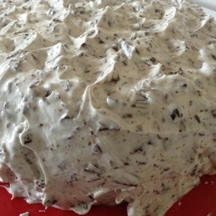 a cake with white frosting sitting on top of a red plate