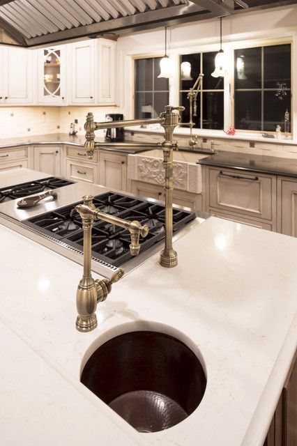 a kitchen with an oven, sink and stove top in the middle of the room