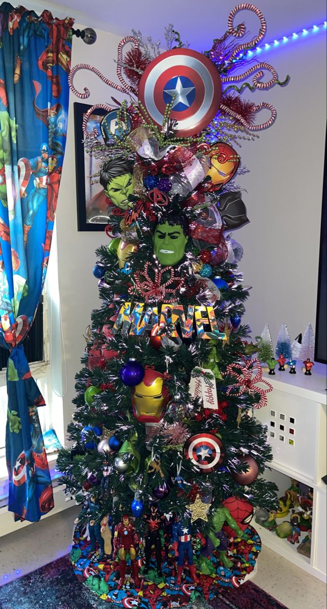 a decorated christmas tree in the corner of a room with captain america decorations on it