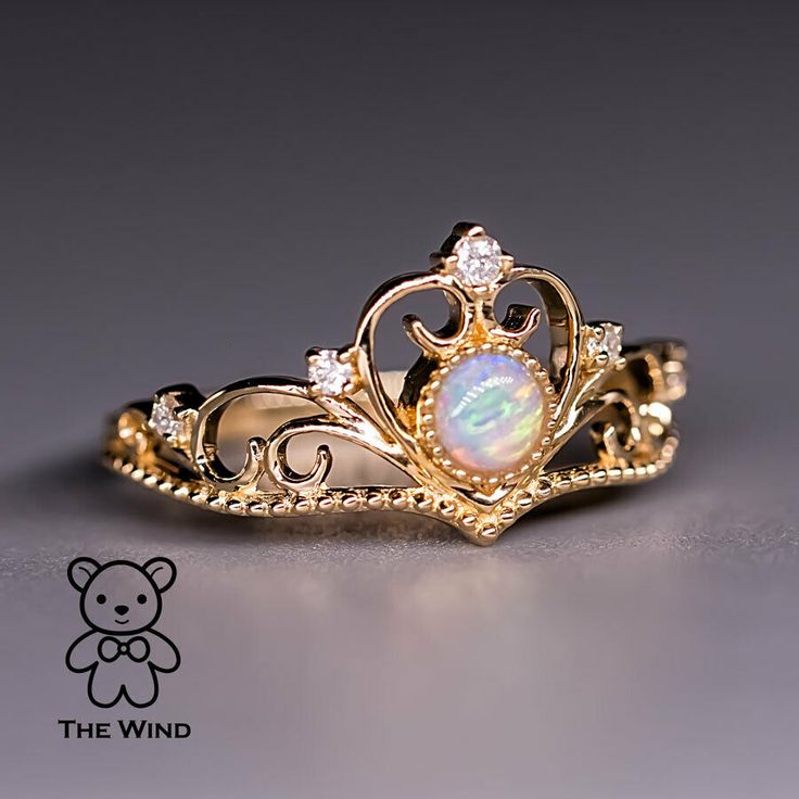 a gold ring with an opal in the center and diamonds on it's sides