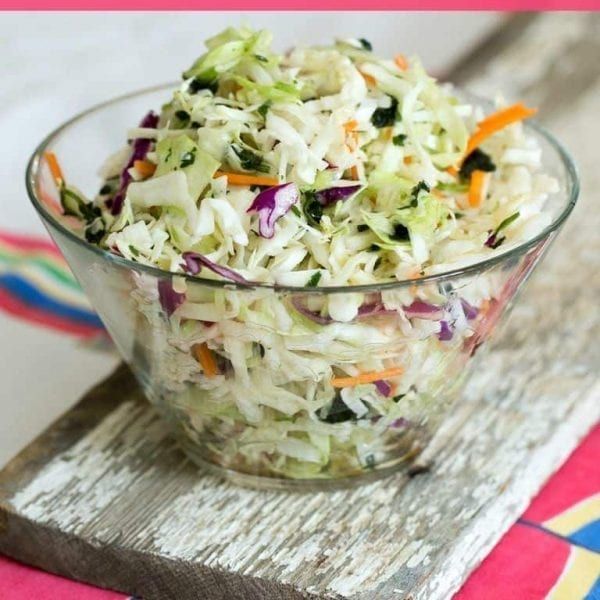 a glass bowl filled with coleslaw and carrots