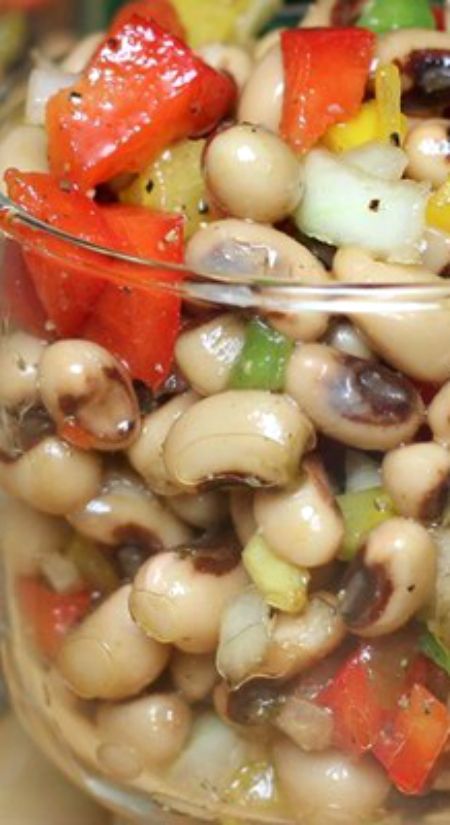 a glass bowl filled with beans and vegetables