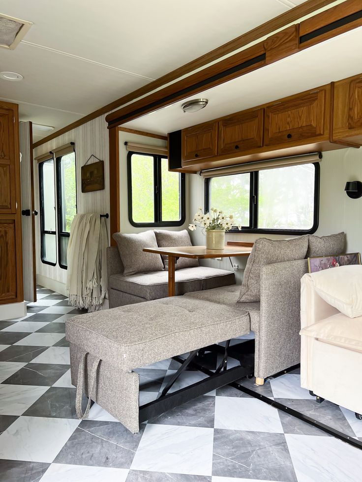 a living area with couches, tables and cabinets in a recreational vehicle or rv