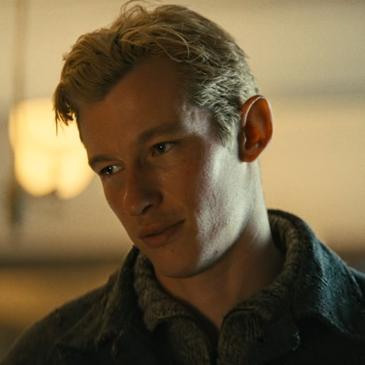 a close up of a person wearing an earring and looking at the camera with a serious look on his face