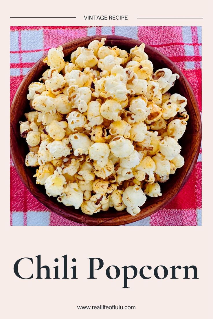 a bowl filled with popcorn on top of a red and white checkered table cloth