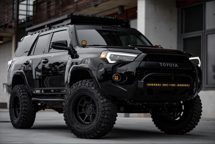 a black toyota truck parked in front of a building