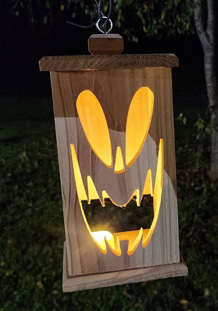 a wooden lantern with an image of a pumpkin on it's face and eyes