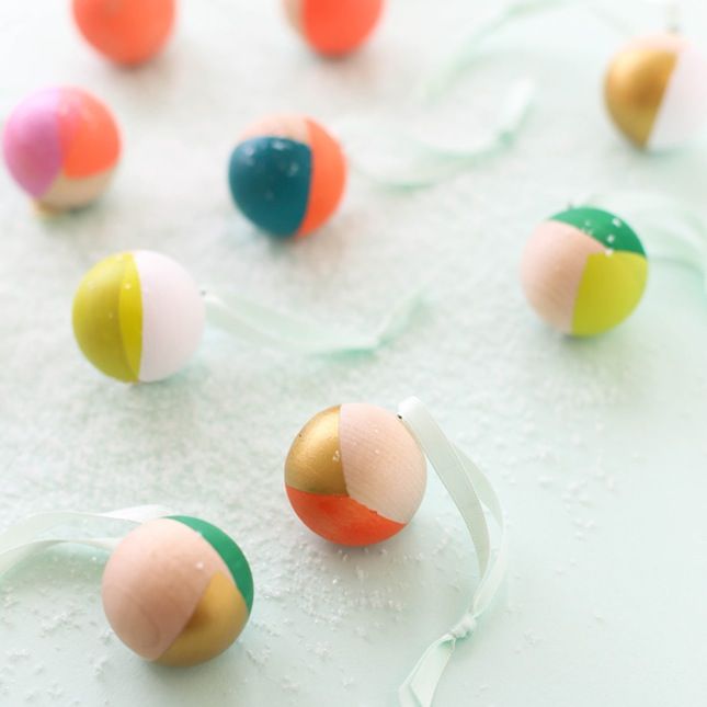 some colorful balls are on a white surface with water droplets around them and streamers