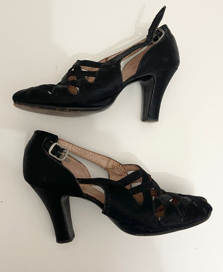 These are a wonderful pair of shoes dating from the 1940's. They have a great criss cross design on the front and a high heel. There is a strap and side buckle. The shoes are made from leather with a black satin outer cover. They have leather soles and are stamped 'Made in Hungary'  The overall condition is good. There is wear to the sole and the leather is a little stiff. There are some tiny tears on the front sides as well as some marks. This is to be expected from shoes of this age and they h Retro Heels With Buckle Closure For Formal Events, Retro Closed Toe Heels With Buckle, Vintage Heels With Low Heel And Heel Loop, Vintage Low Heel Heels With Padded Heel, Vintage Closed Toe Heels For Vintage Events, Retro Evening Heels With Heel Loop, Vintage Heels With Heel Strap And Round Toe, Vintage Heels With Heel Strap For Formal Occasions, Vintage Low Heel Shoes With Heel Loop