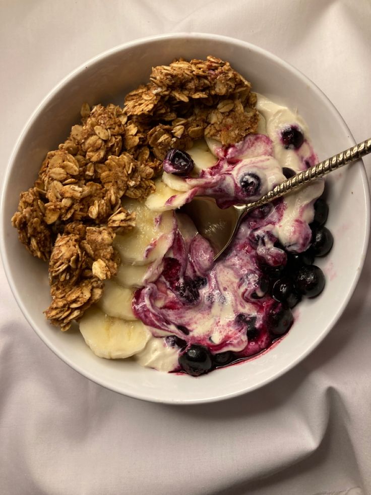 a bowl filled with granola, blueberries and yogurt