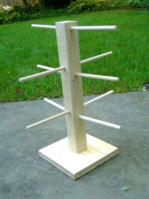 a wooden rack with several sticks sticking out of it's sides in the middle of a yard