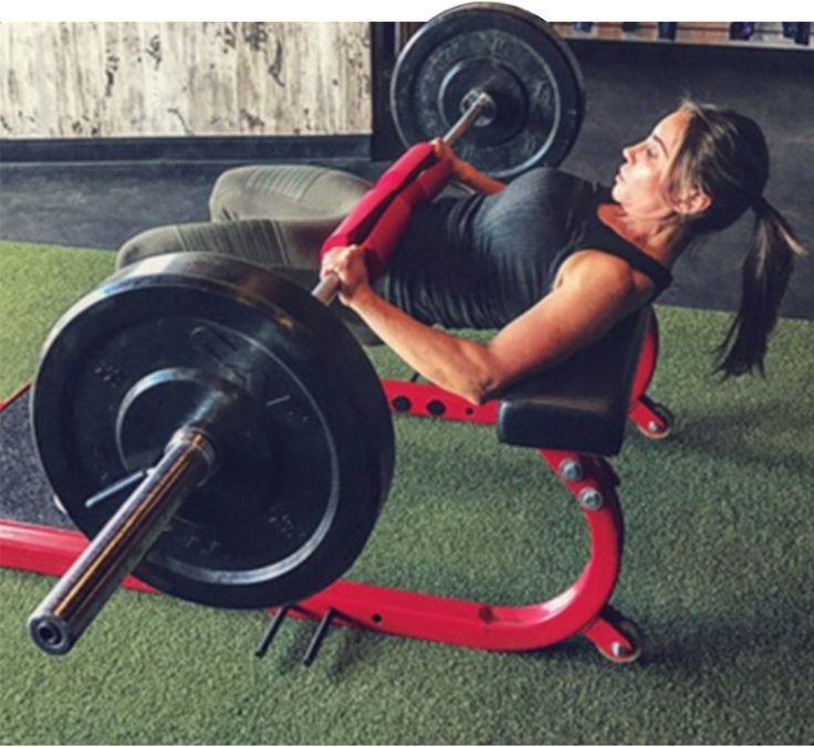 a woman is doing squats with a barbell