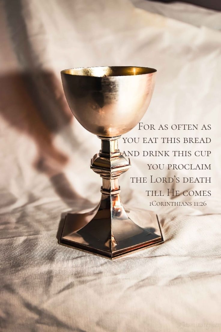 a silver cup sitting on top of a bed next to a quote from the book, for as often as you eat this bread and drink this cup