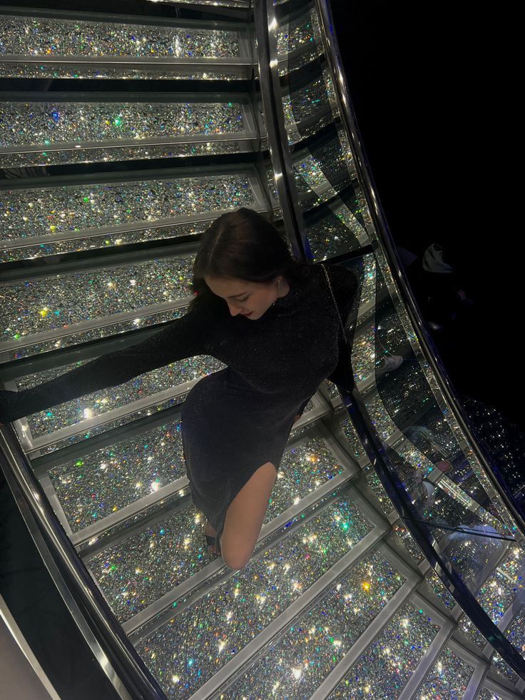 a woman is walking down an escalator with lots of sparkles on it