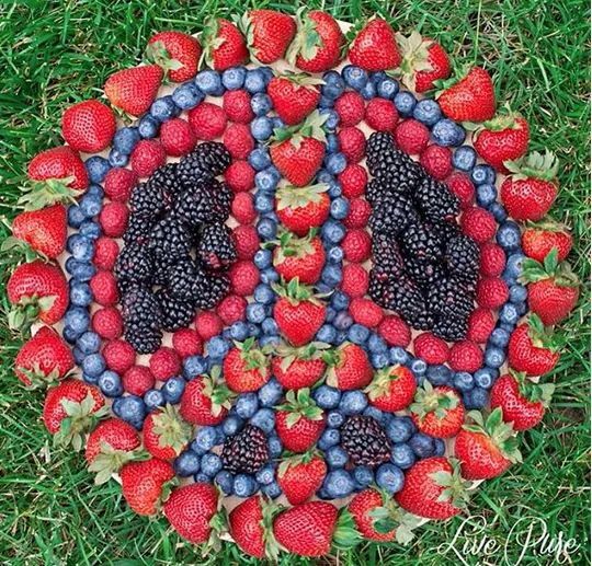 a circular arrangement of berries and blackberries arranged in the shape of a peace sign