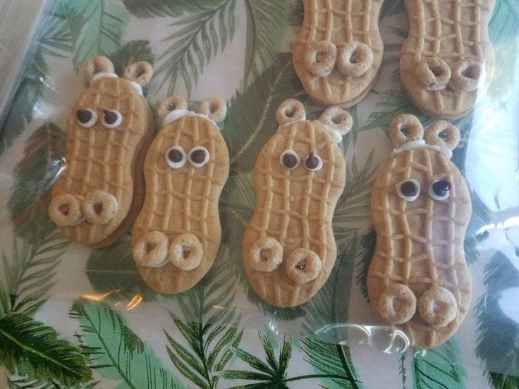 some kind of animal shaped cookies with googly eyes and palm leaves on the table