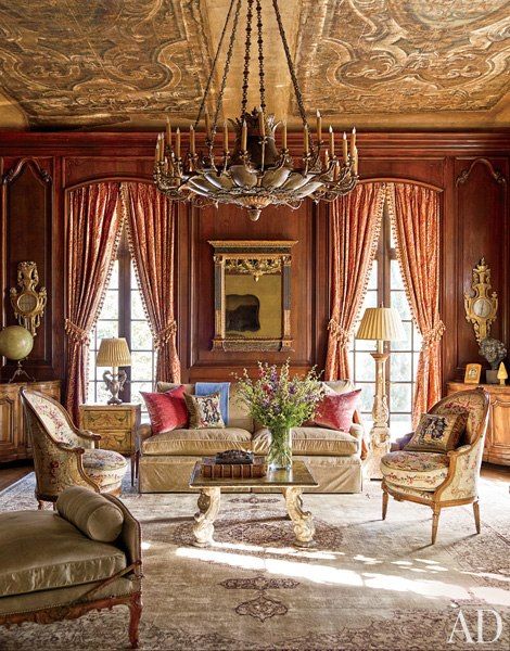 a living room with couches, chairs and a chandelier hanging from the ceiling