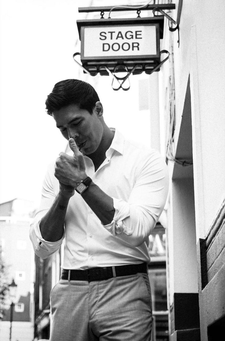 a man standing in front of a stage door with his hands clasped to his face