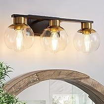 three light bathroom fixture with glass globes on the wall and wood frame around it