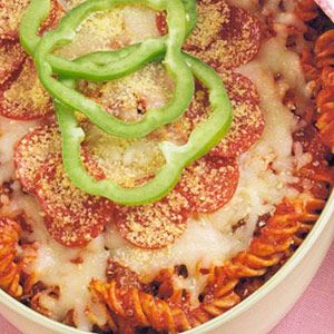 a bowl filled with pasta covered in cheese and green bell peppers on top of it