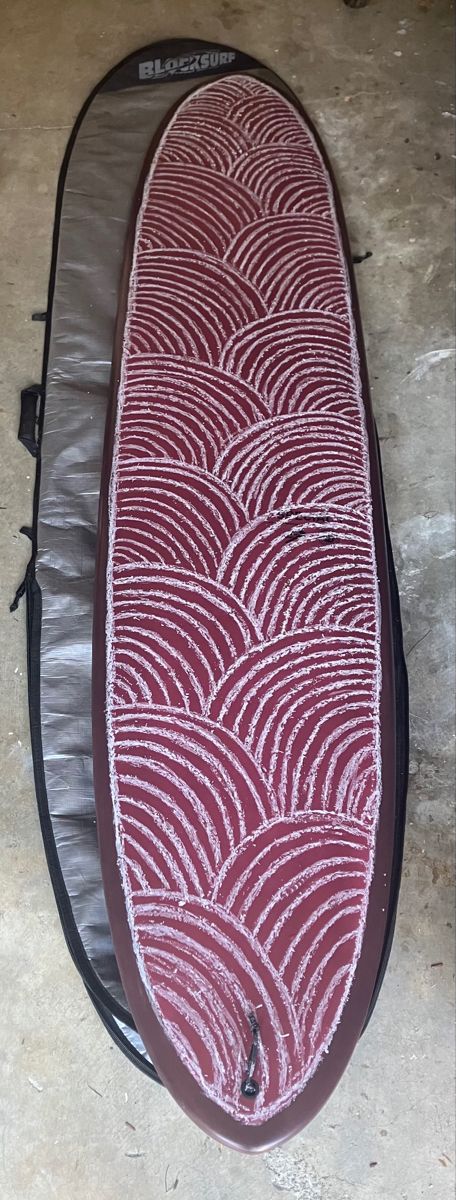 a surfboard is laying on the ground with its cover pulled up to it's side