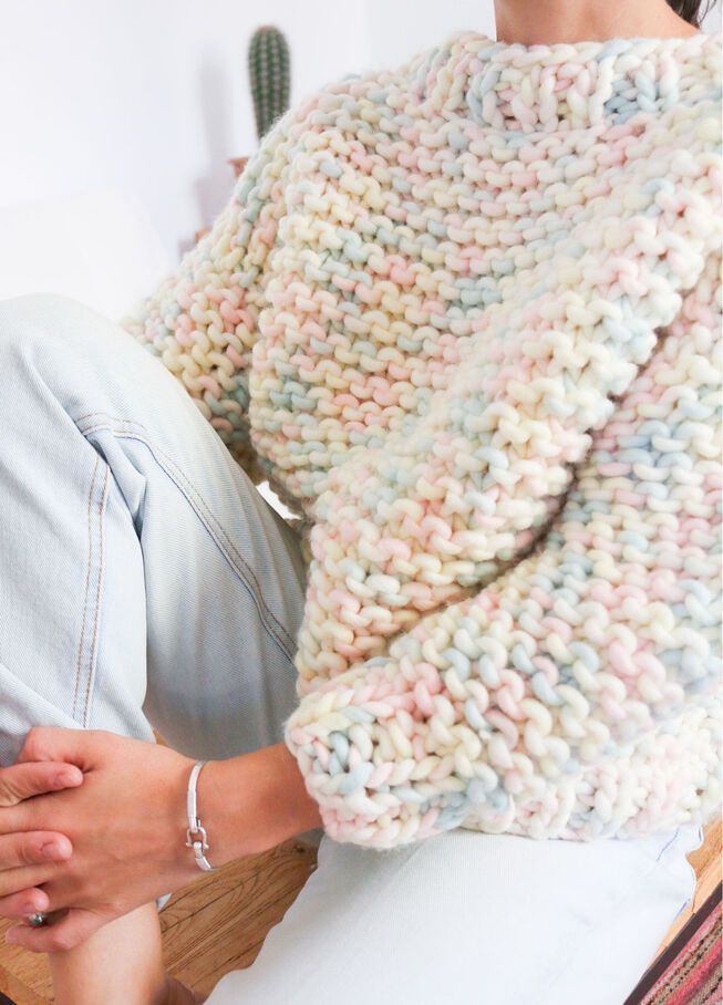 a woman laying on top of a bed covered in a blanket