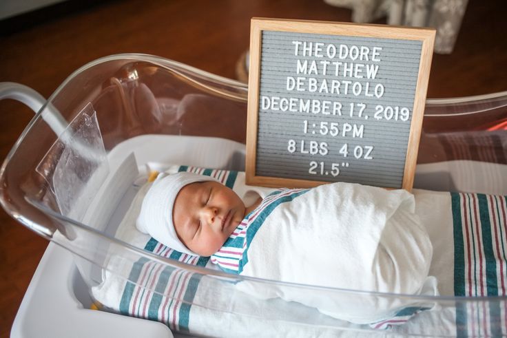 a baby is in a plastic container with a sign