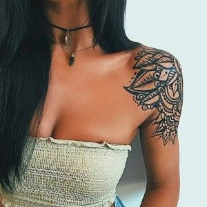 a woman with long black hair and tattoos on her arm